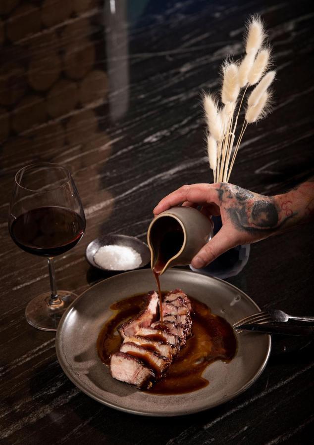 Qt Queenstown Exterior photo A chef seasoning a dish